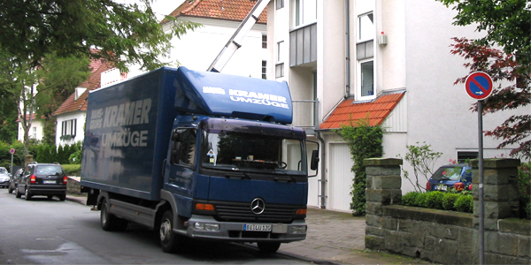 Ein LKW des Umzugsunternehmen KRAMER steht vor einem Haus in Detmold.