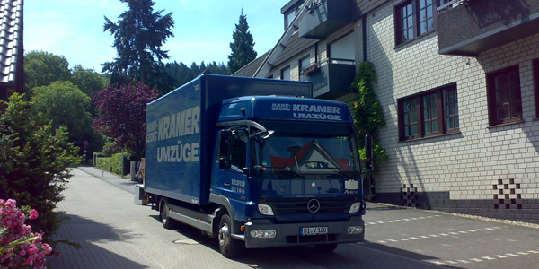 Ein LKW des Umzugsunternehmen KRAMER steht vor einem Haus in Gütersloh.